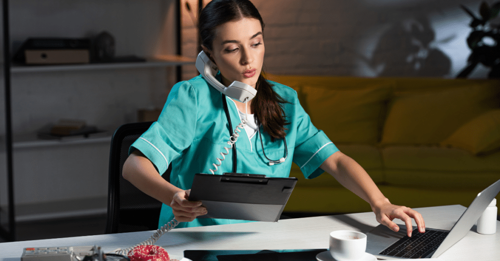 Dedicated nurse in scrubs effectively multitasking during the night shift, managing a phone call and reviewing information on a clipboard. Illustrating strategies for successfully surviving and thriving during overnight nursing duties.