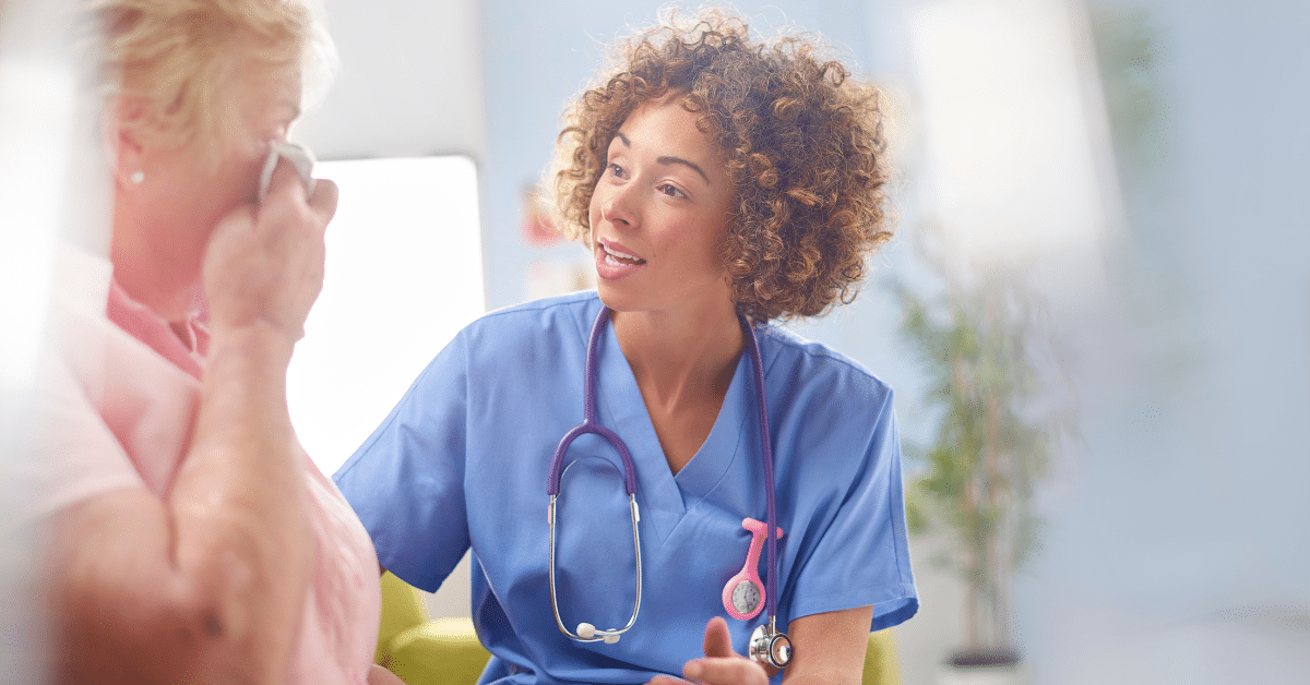 Compassionate nurse attending to a patient while consoling a distressed family member during patient care decisions conflicts.