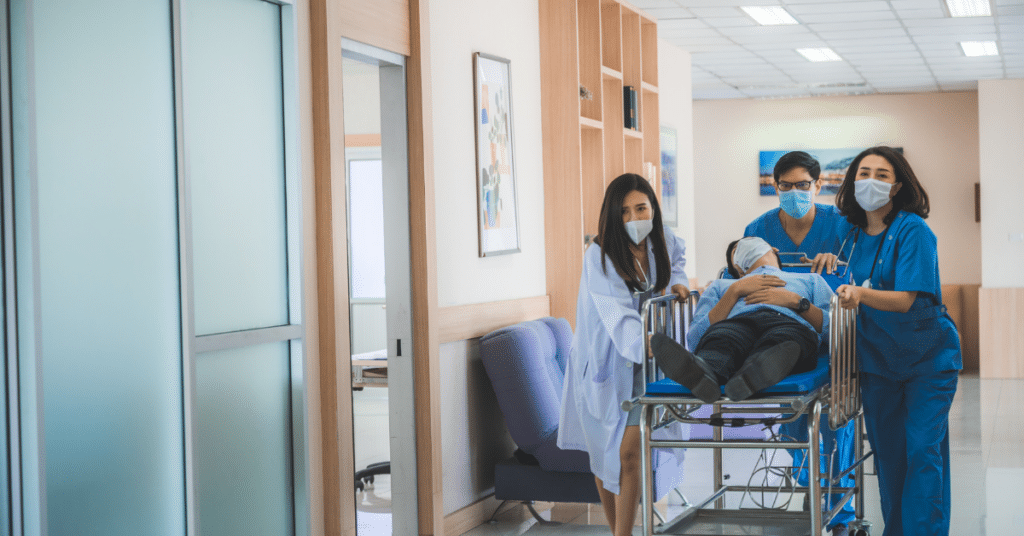 Emergency department doctors and nurses providing care for an injured patient in a hallway, emphasizing the concept of 'Hallway Patients' in healthcare.