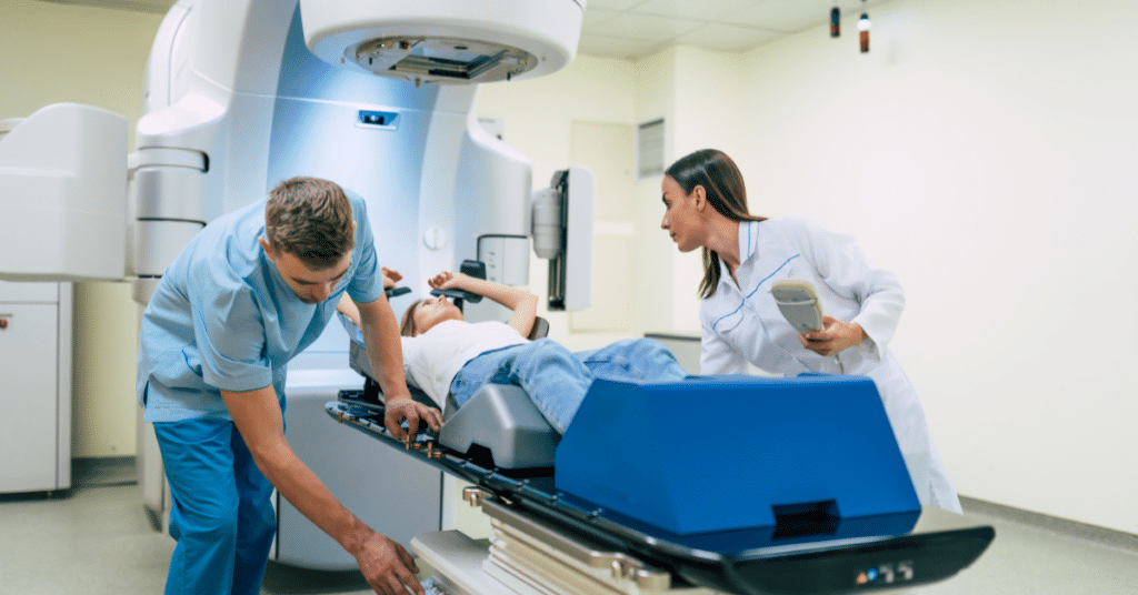 Radiologic technologist operating imaging equipment with a patient.