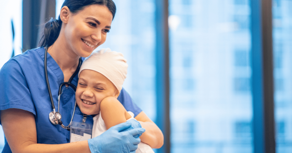 A female nurse with a warm and smiling expression embraces a patient during cancer treatment, creating a heartwarming moment of connection. The patient appears happy and comforted, highlighting the positive impact of nurses' attitudes on patient care.