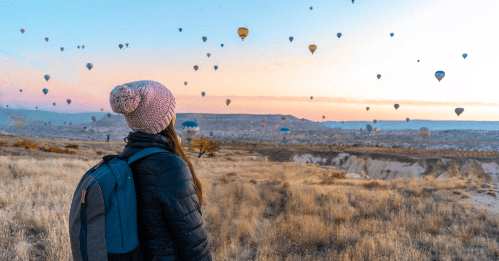 Women observing hot air balloons in New Mexico. This scene captures the allure of New Mexico as an underrated travel destination for nurses, highlighting its unique experiences and scenic beauty.