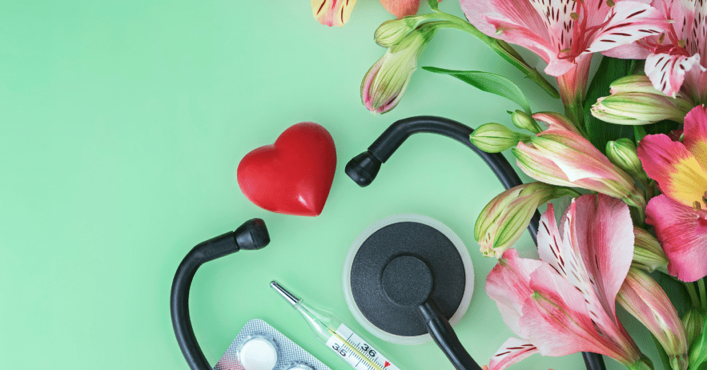 An arrangement of pink lilies and a red heart, alongside a stethoscope. These are Valentine's Day gifts for nurses.